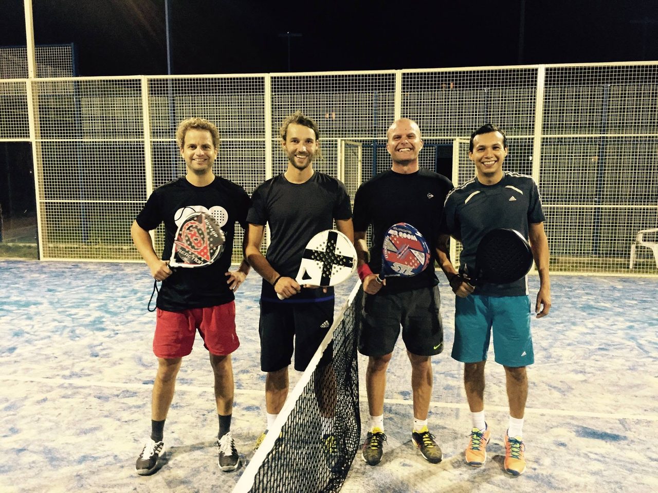 Vier Padelspieler am Netz eines Outdoor-Courts in Berlin, August 2015
