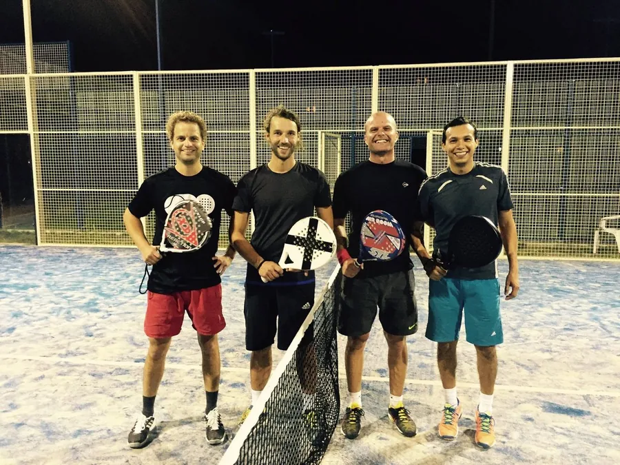 Vier Padelspieler am Netz eines Outdoor-Courts in Berlin, August 2015