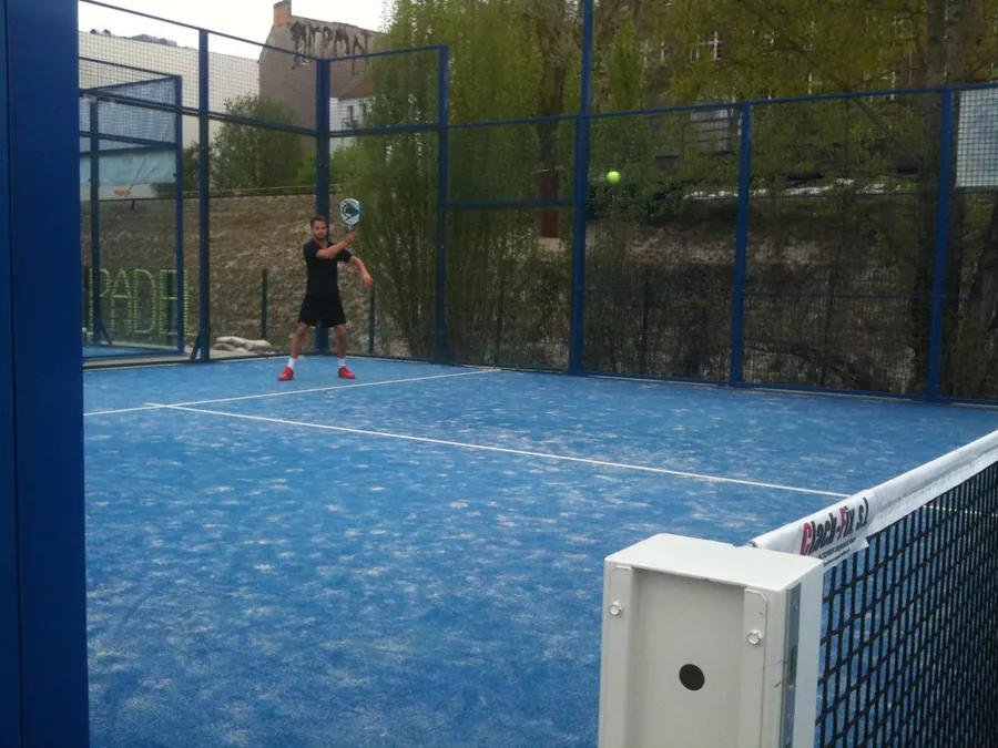 Padelspieler beim Volley auf dem blauen Outdoor-Court von Padel Berlin, 2013